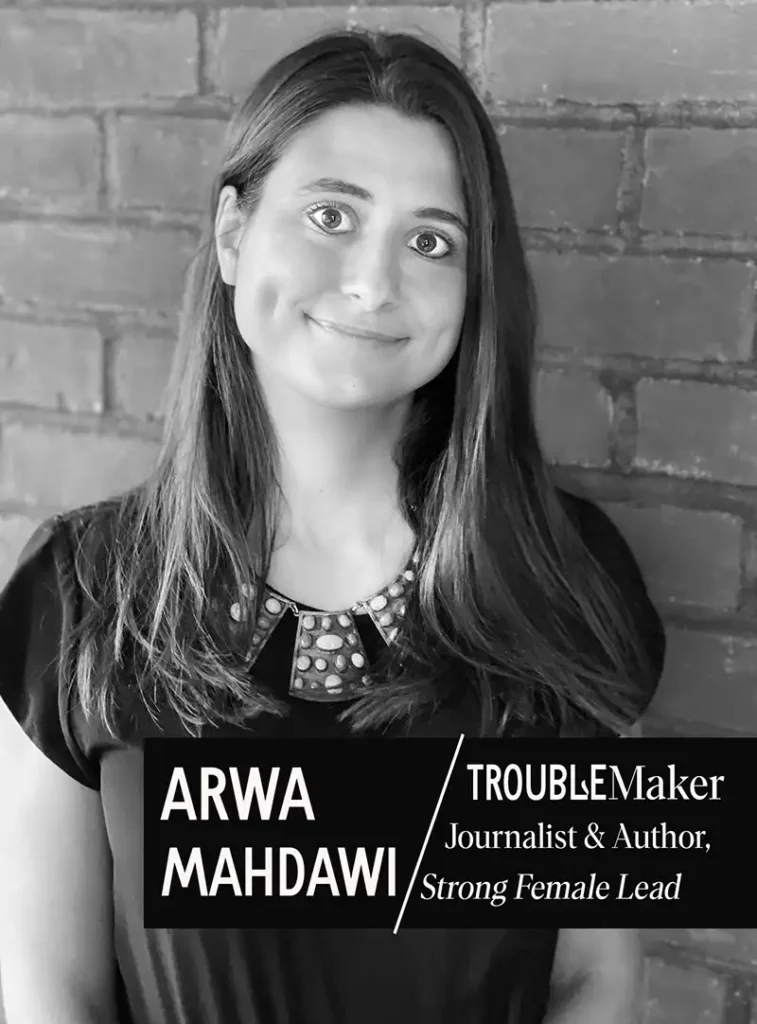 A black and white portrait of Arwa Mahdawi, a woman with long dark hair, smiling and looking directly at the camera. She is wearing a dark top with an embellished neckline, leaning against a brick wall. Overlays read "ARWA MAHDAWI" and "TROUBLEMaker Journalist & Author, Strong Female Lead".
