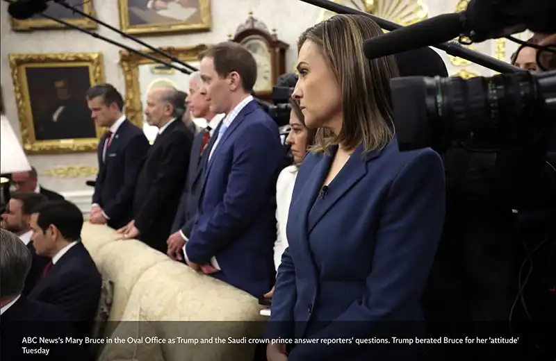 ABC News' Mary Bruce, a woman with shoulder-length brown hair, wearing a dark blue suit jacket, stands looking to the right. She is surrounded by cameras and other individuals in suits, in a formal room with ornate white and gold decor and framed paintings. The caption states she is in the Oval Office as Trump and the Saudi crown prince answer reporters' questions, and Trump "berated Bruce for her 'attitude'".